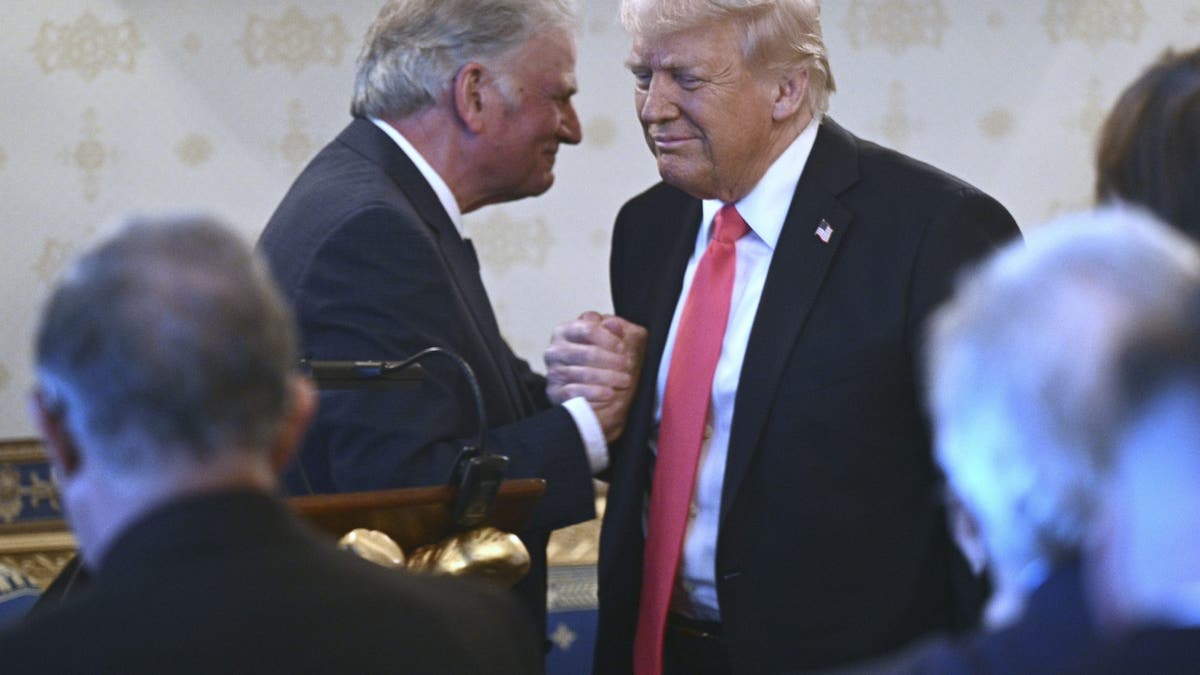 President Donald Trump greets Rev. Franklin Graham during an Easter prayer service and dinner in the Blue Room of the White House in Washington, Wednesday, April 16, 2025. (Pool via AP)