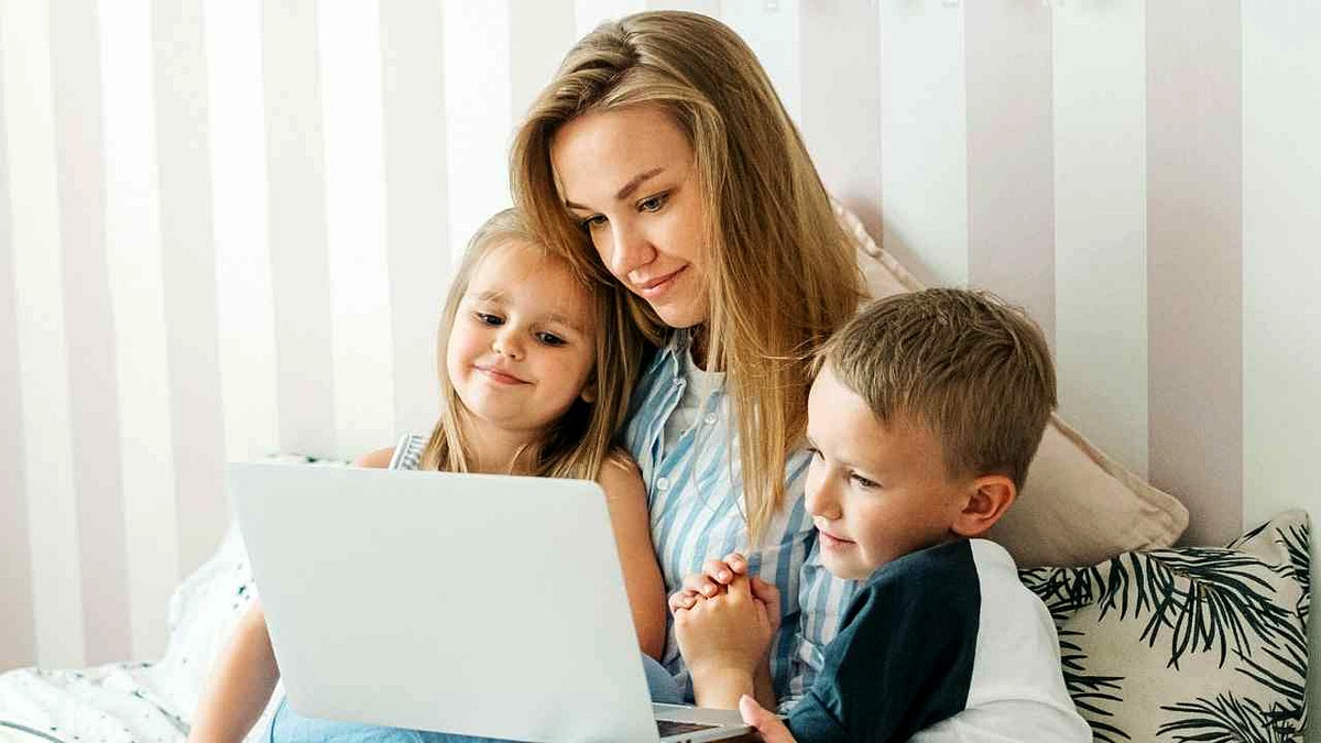 A mother browses the internet with her children.